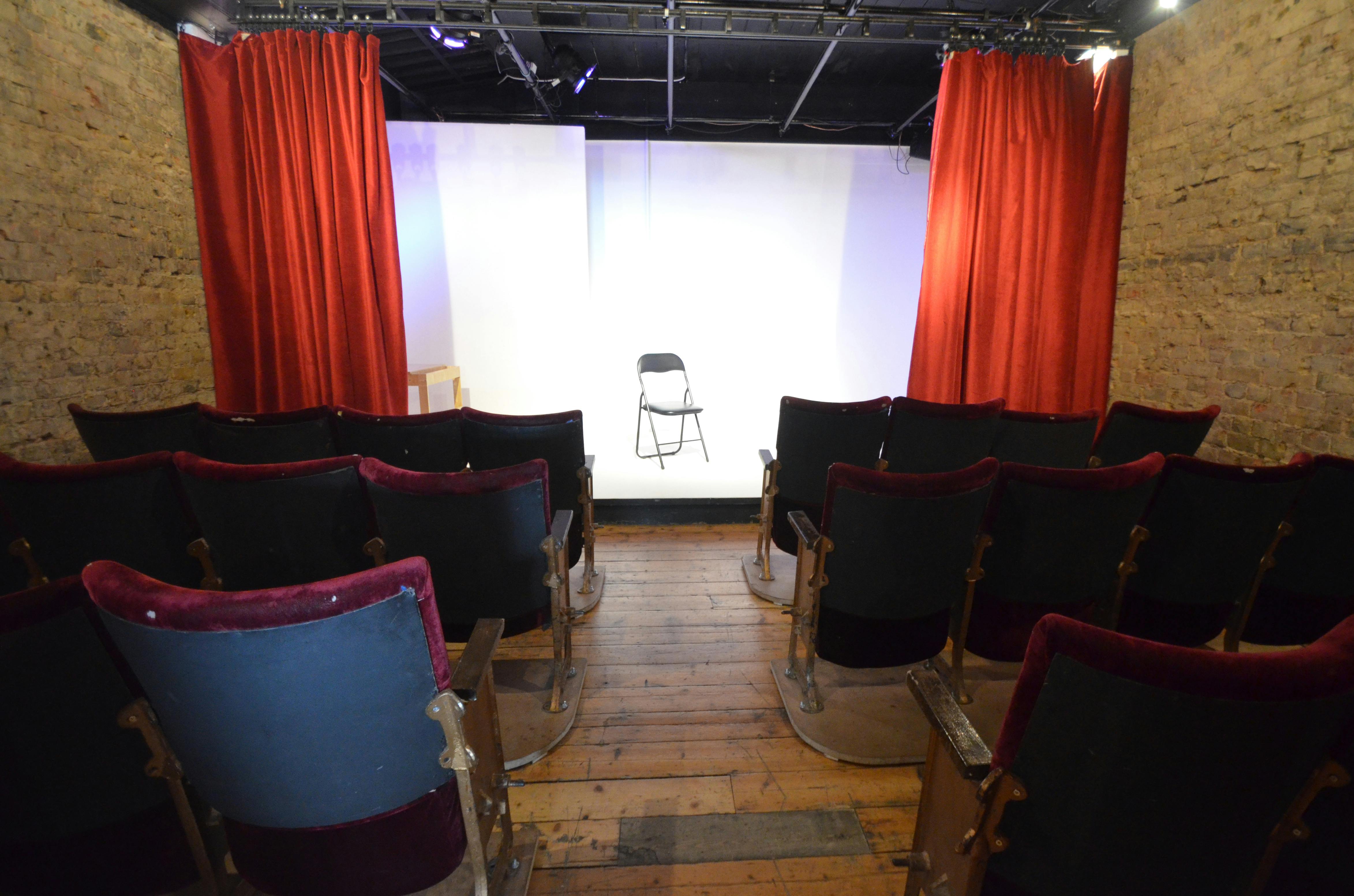 Intimate Theatre Space with red curtains for workshops and presentations at Calder Theatre Bookshop.